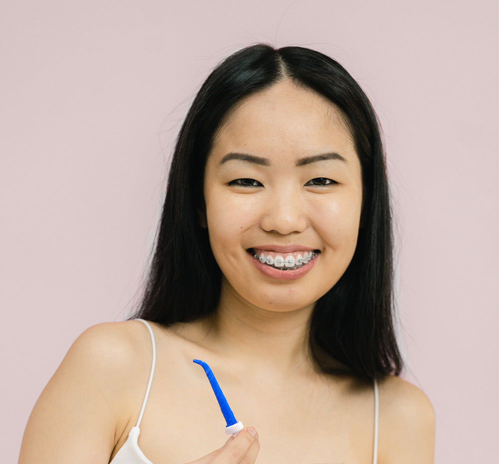 Girl with braces holding ShowerFloss pik