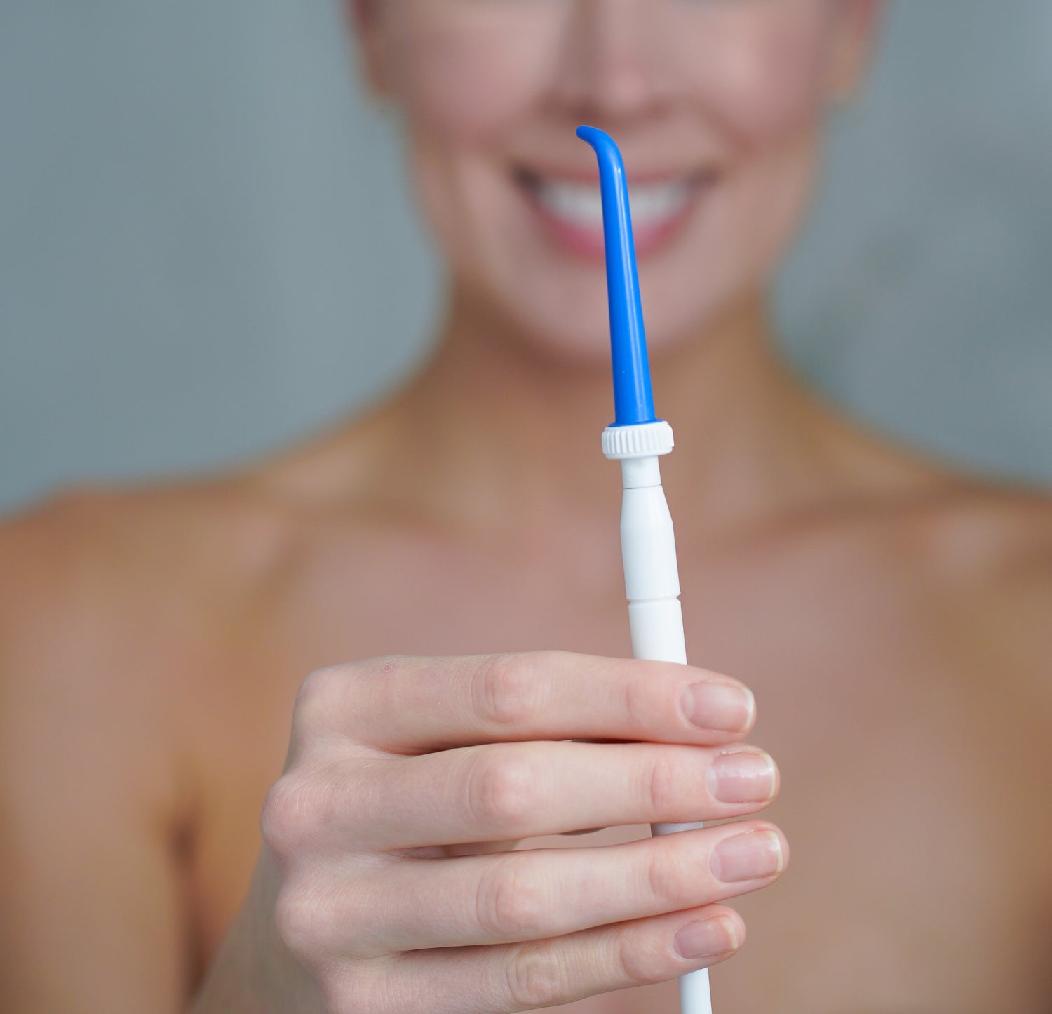 Woman holding ShowerFloss device